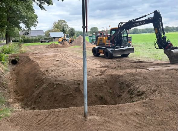 Pekkeriet graafmachine aan het werk bij grondverzet